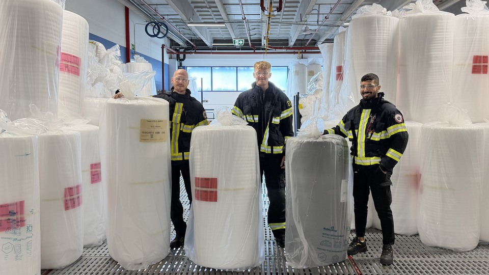 Tre deltidsbrandmän står uppradade på sitt ordinarie arbete, klädda i sina larmställ. Foto.