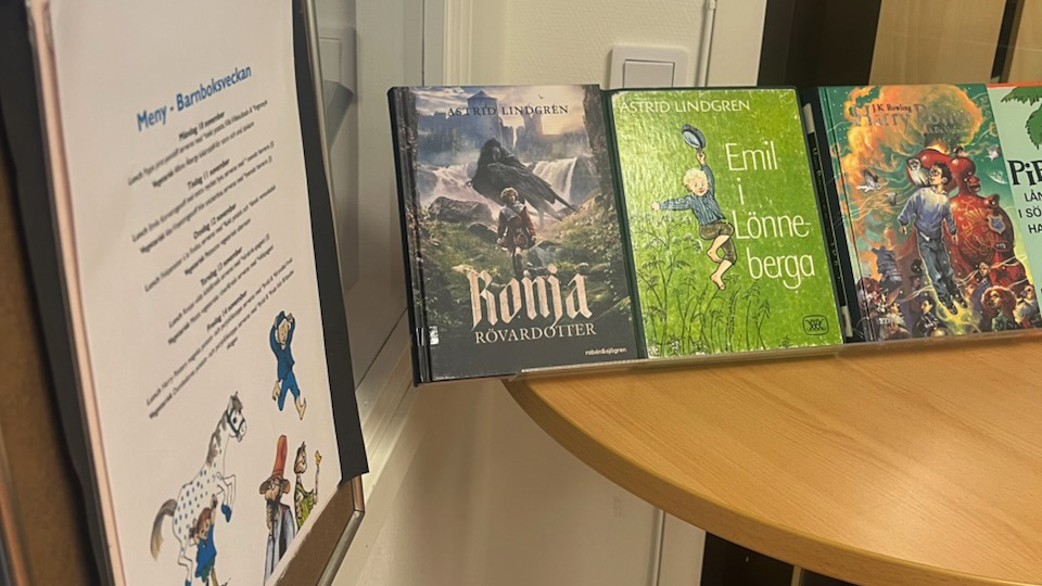 Böcker och en affisch med veckans skolmeny. Foto