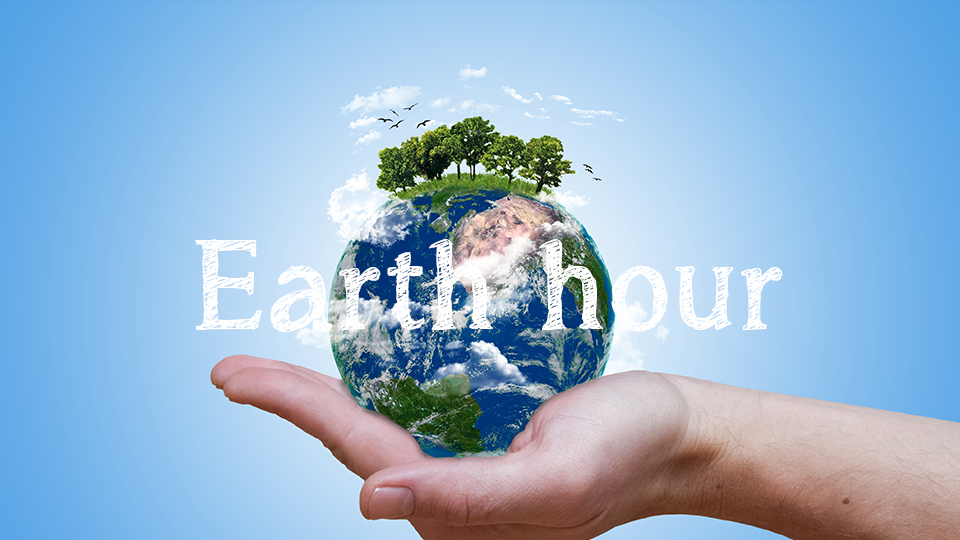 En illustrerad jordglob där en hand håller i den med texten earth hour ovanpå bilden. 