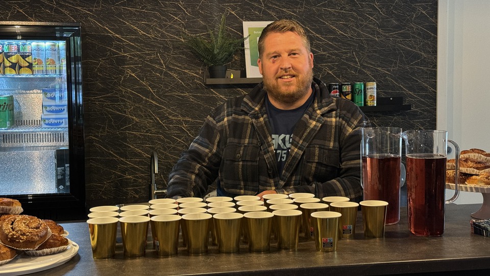 En man bakom en bardisk med fika.