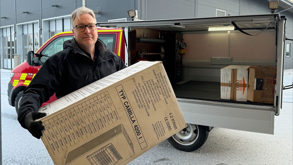 Utbildningsansvarig Räddningstjänsten Aneby lastar gasolkaminer i en bil. 