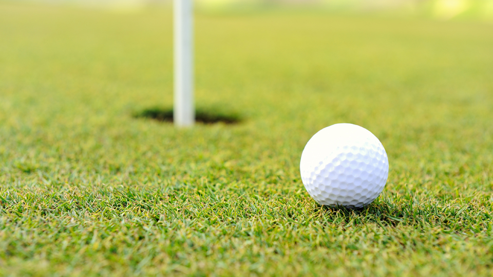 En golfboll nära hålet på golfbanan. 