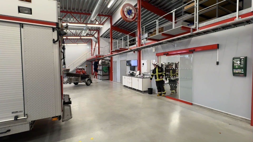 Brandmän ombyyta och klara för utryckning påväg till brandbilen på brandstationen. Foto. 