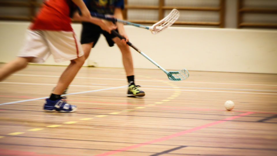 Två barn spelar innebandy. Foto. 