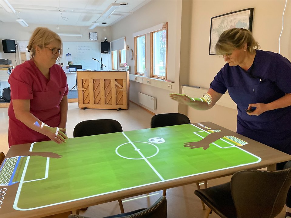 Annica Friman och Charlotte Ekberg arbetar på Baggen, en daglig verksamhet i Aneby kommun. På bilden spelar de ett av spelen på det magiska bordet.